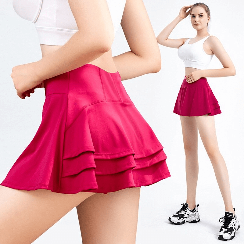 Woman wearing a stylish pink pleated sports skirt with a white sports bra, showcasing comfort and performance for golf and tennis.